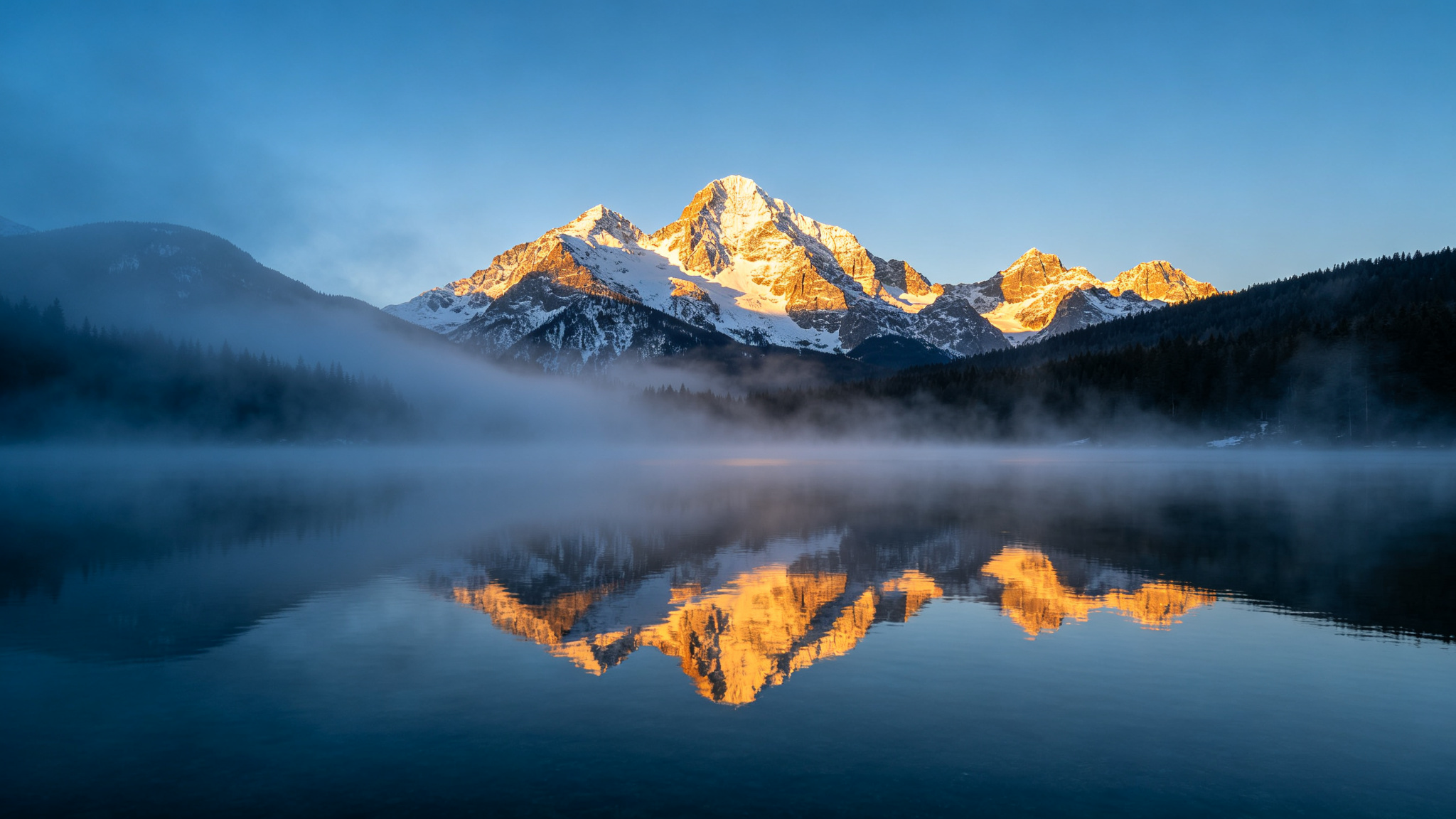 晨雾中的雪山湖泊倒影